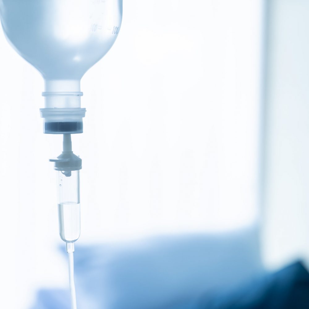 Saline solution drip for treatment patient with copyspace - blue white balance processing